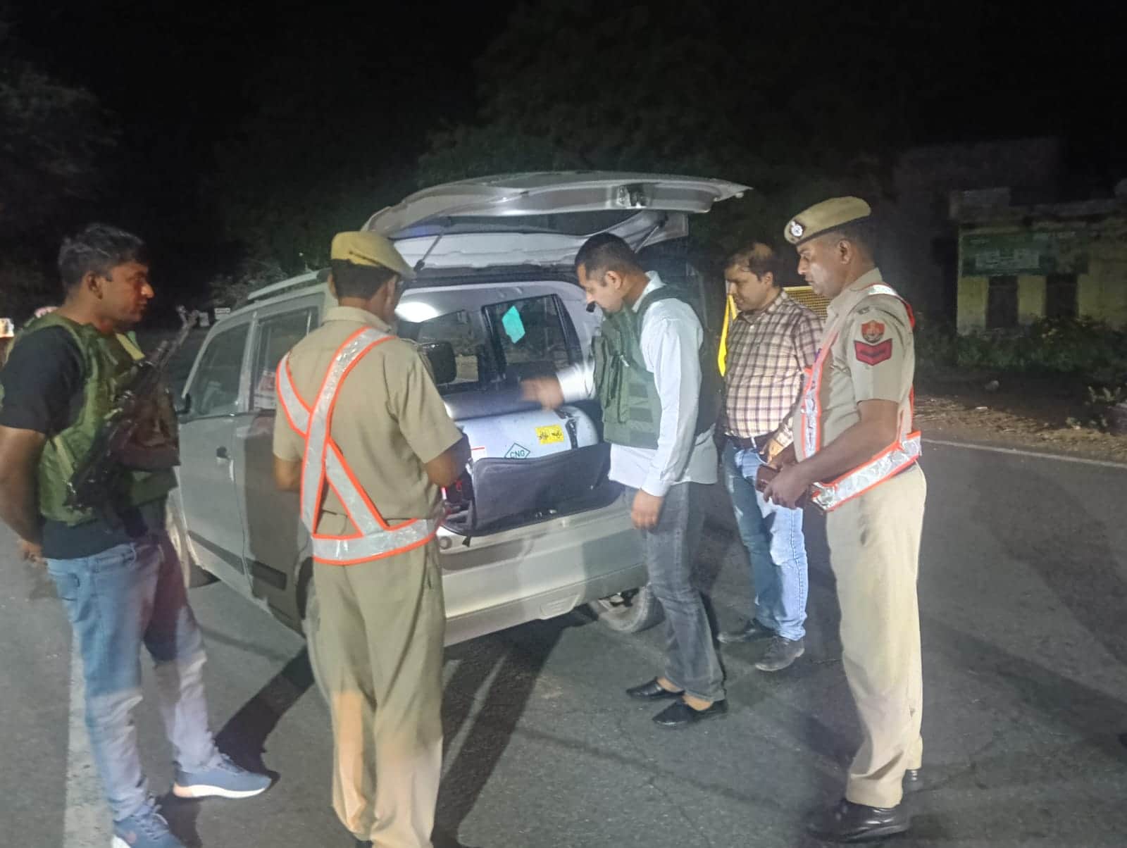 गाड़ियों की गहन जांच करते हुए पुलिसकर्मी। 