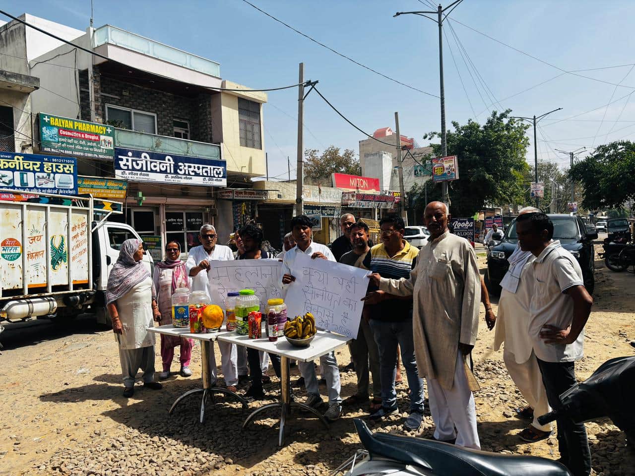 रोड के बीच दुकान लगाकर विरोध प्रदर्शन करते दुकानदार। संवाद