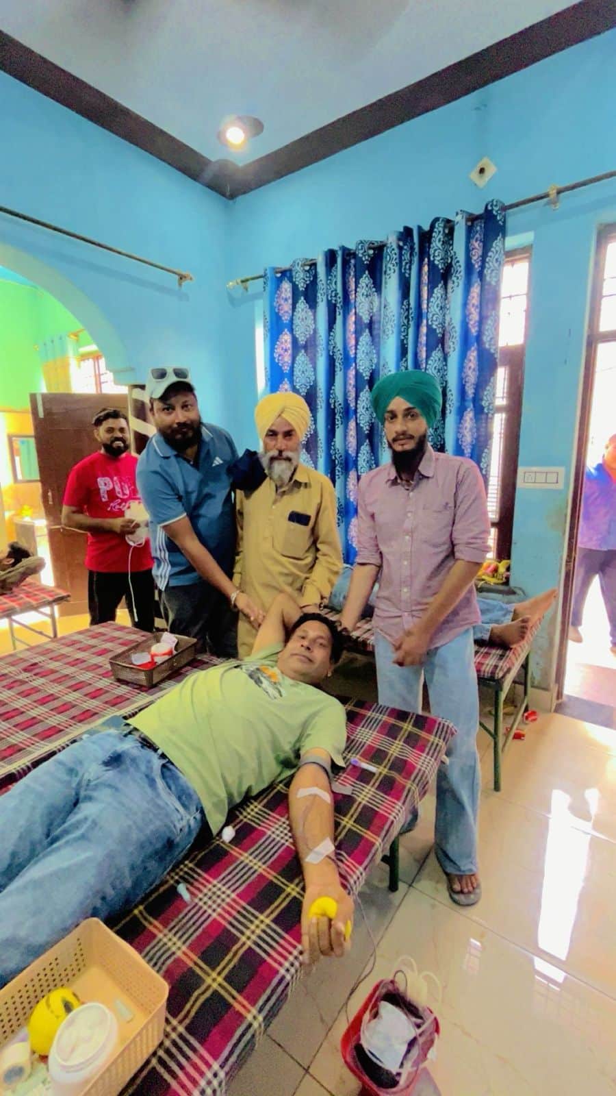 शिविर में रक्तदाता के साथ आयोजक। स्वयं