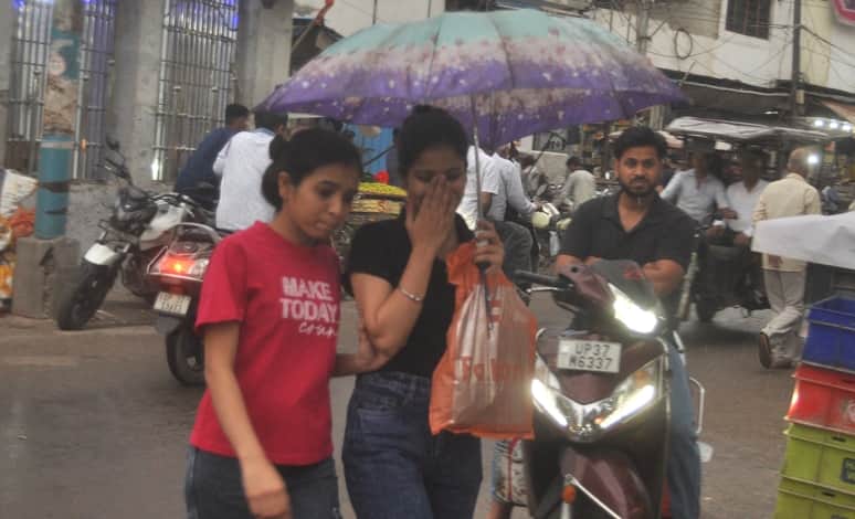 चंडी रोड पर बारिश में छाता लगाकर सड़क पर जाती युवतियां। संवाद
