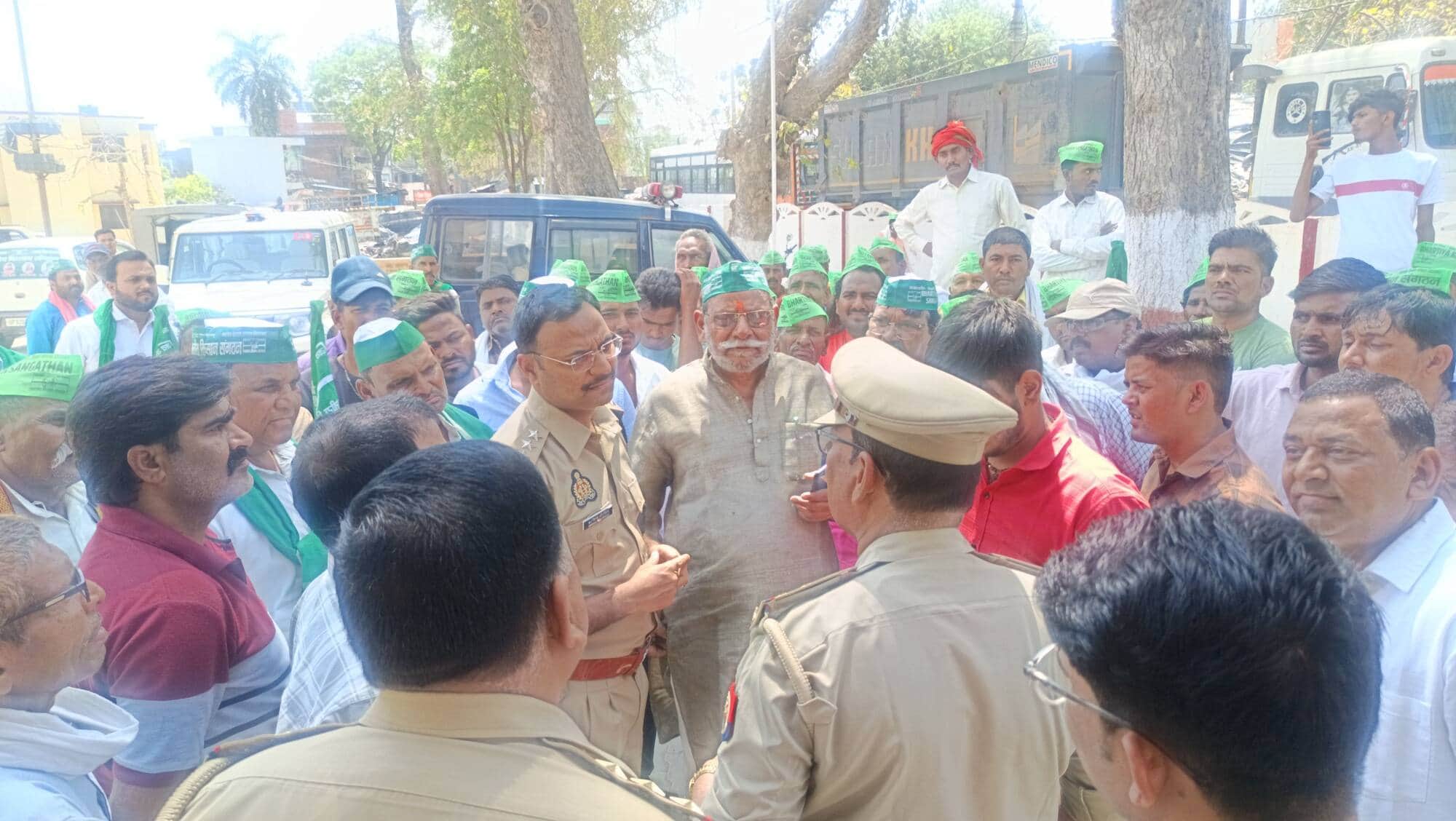 फोटो-11-कोतवाली के बाहर प्रदर्शन कर रहे भारतीय किसान संगठन के लोगों से बात करते सीओ अरविंद चौरस