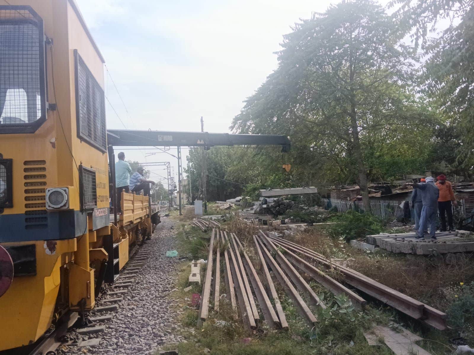 फोटो-27-गंगा नदी पुल पर रेलवे की मरम्मत कराने के लिए ट्रैक के किनारे रखा अतिरिक्त सामान हटाती म