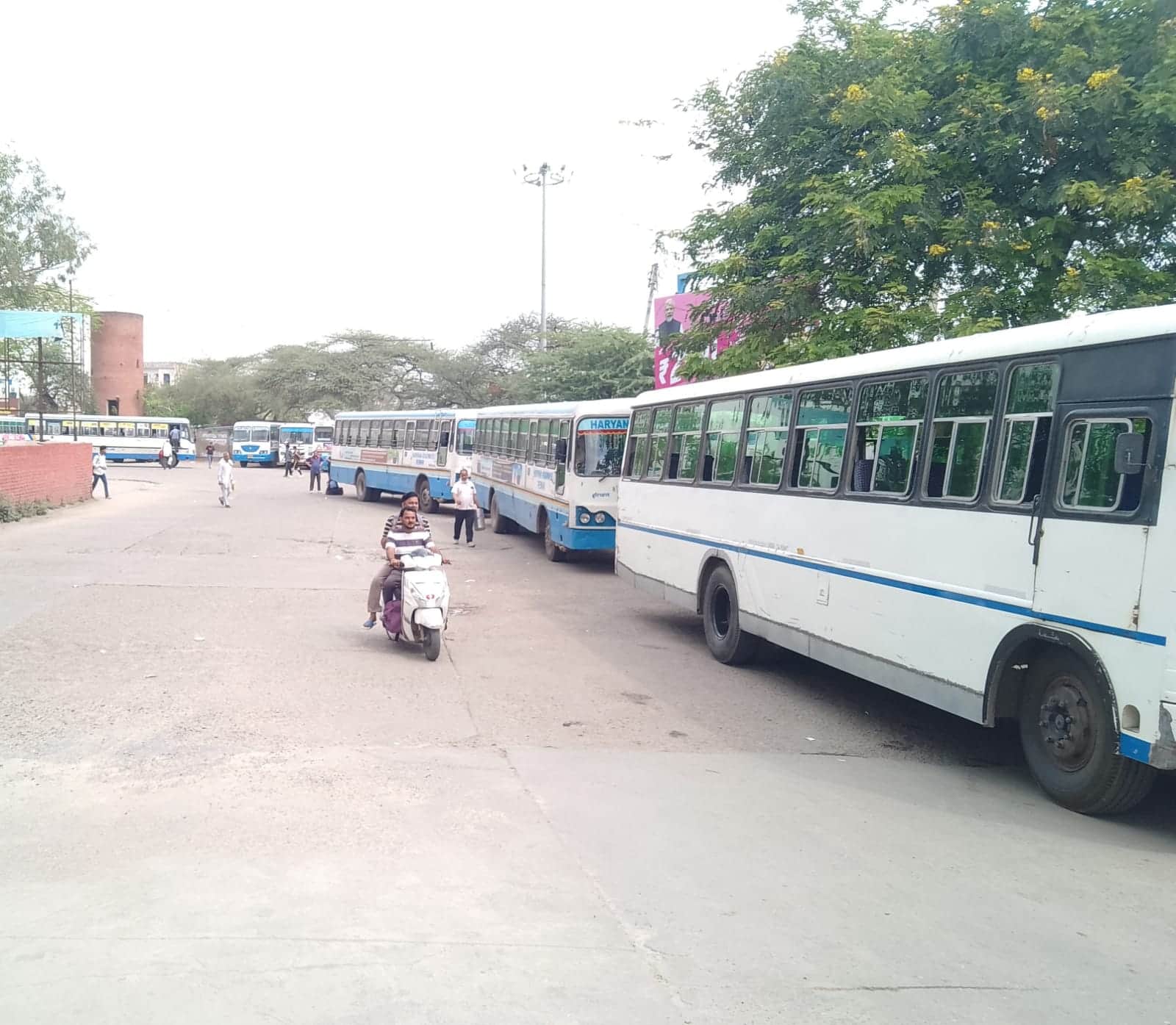 फोटो नंबर- 14रेवाड़ी रूट के लिए कतार में खड़ी बस और स्कूटी से बस स्टैंड के बाहर जाते युवा। सं