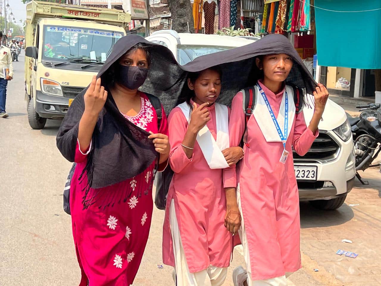 नगर में तेज धूप और गर्मी से बचने के लिए दुपट्टे का सहारा लेकर जाती छात्राएं।संवाद