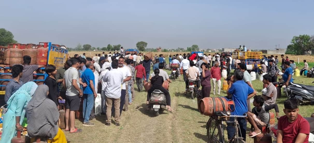 पिलखुवा के परतापुर रोड पर खेतों में सिलिंडर के लिए लगी लोगों की भीड़।संवाद