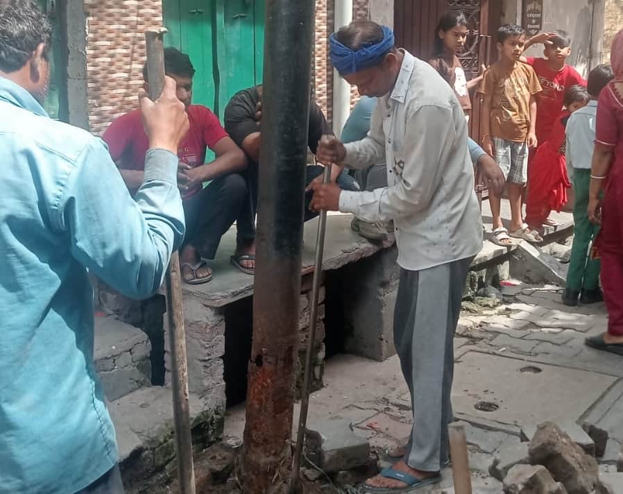 टीचर्स कालोनी में जर्जर खंभे को बदलते विद्युत कर्मी।संवाद