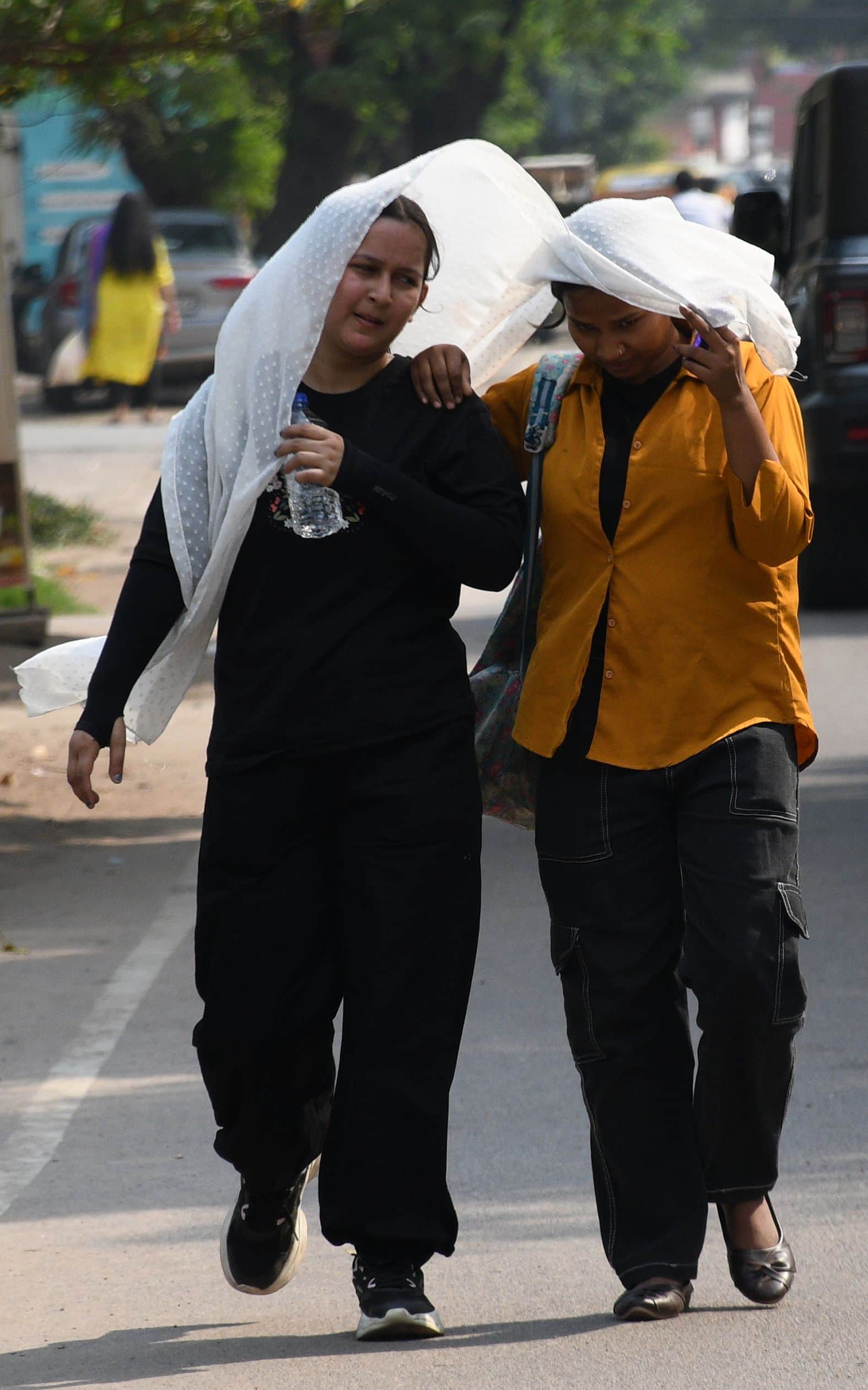 तेज धूप से परेशान लोग।