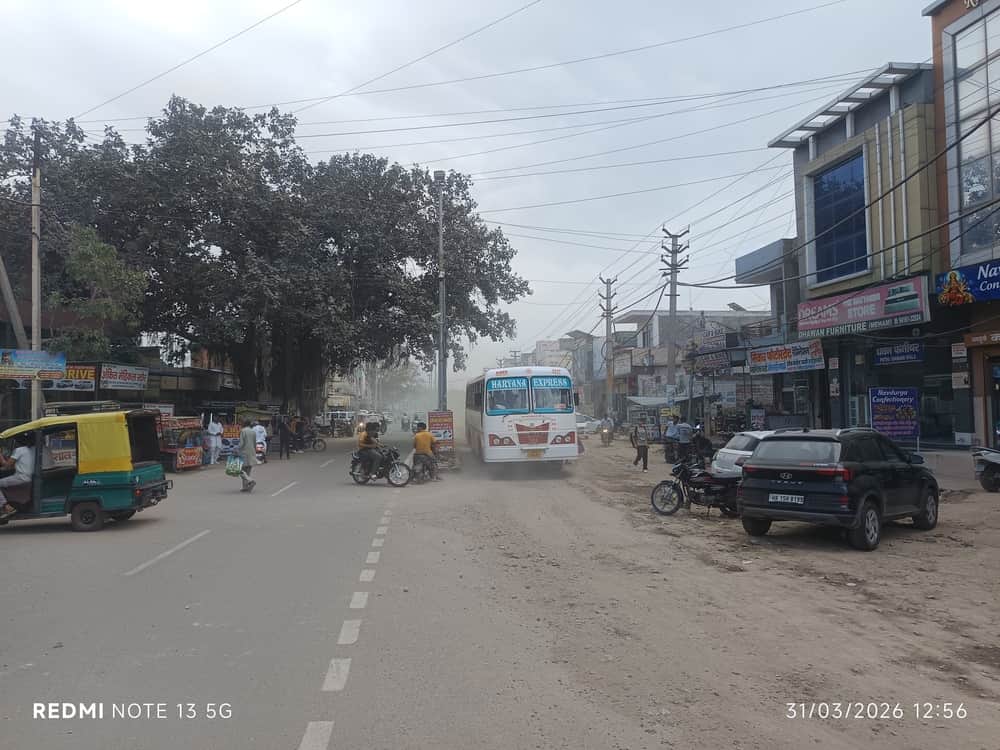 फोटो 01 महम स्थित क्रांति चौक पर बस के साथ उड़ती धूल । संवाद