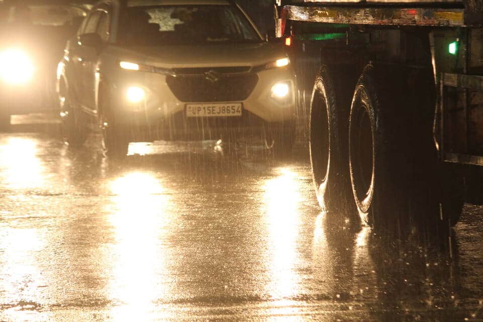 देर रात हुई बारिश के बीच गंतव्य की ओर जाते वाहन। संवाद