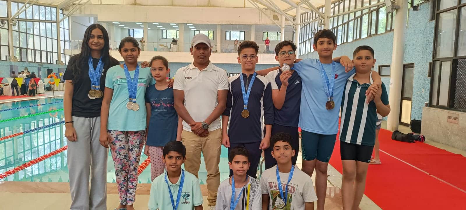  विजेता खिलाड़ी अपने कोच के साथ पदक दिखाते हुए      स्त्रोत  कोच