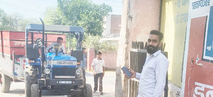 अनाज मंडी में आई गेंहू की ट्राली का नंबर स्कैन करते कर्मचारी। स्त्रोत- स्वयं।