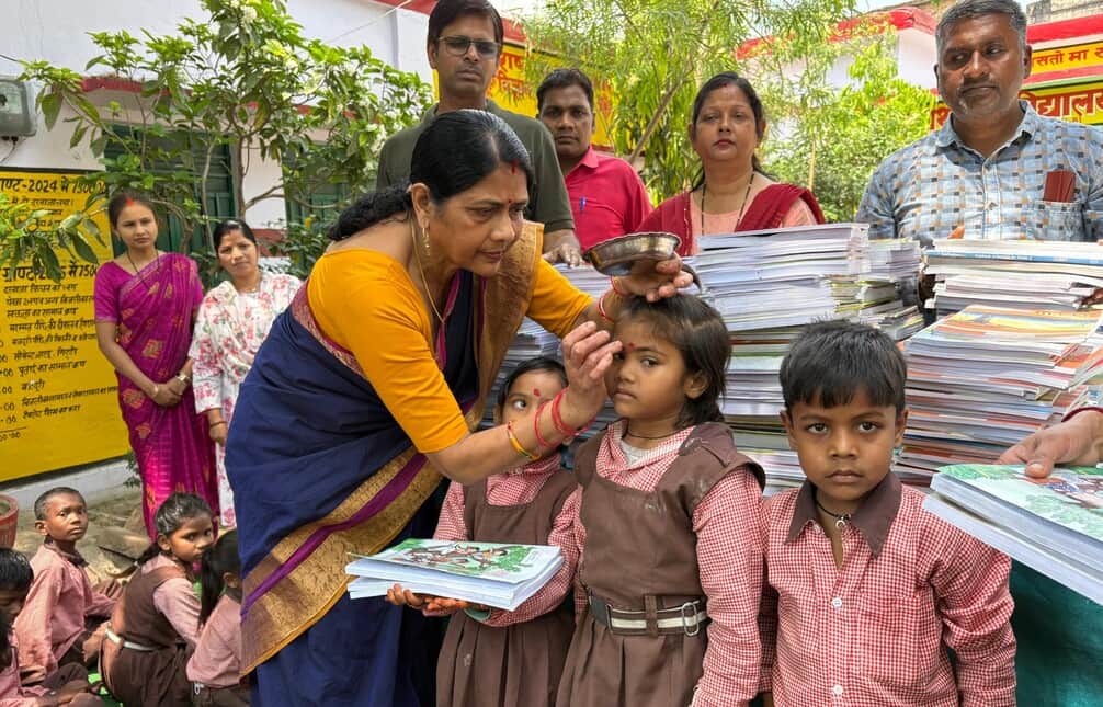 ज्ञानपुर विद्यालय में नए बच्चों को टीका लगा कर स्वागत करती शिक्षिका। संवाद