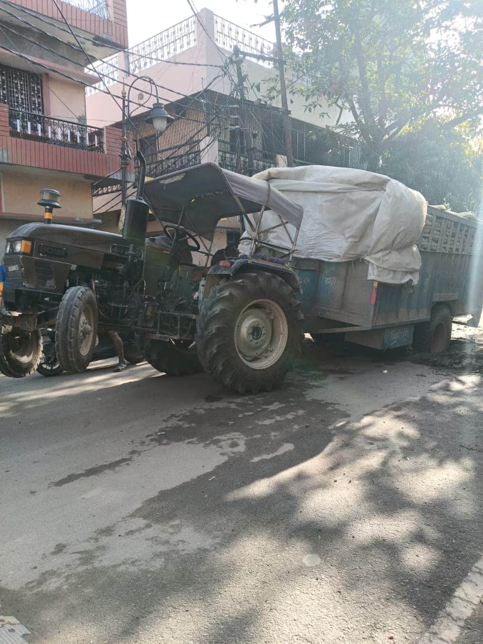 पिलखुवा में सड़क के गड्ढे में फंसा ट्रैक्टर। संवाद