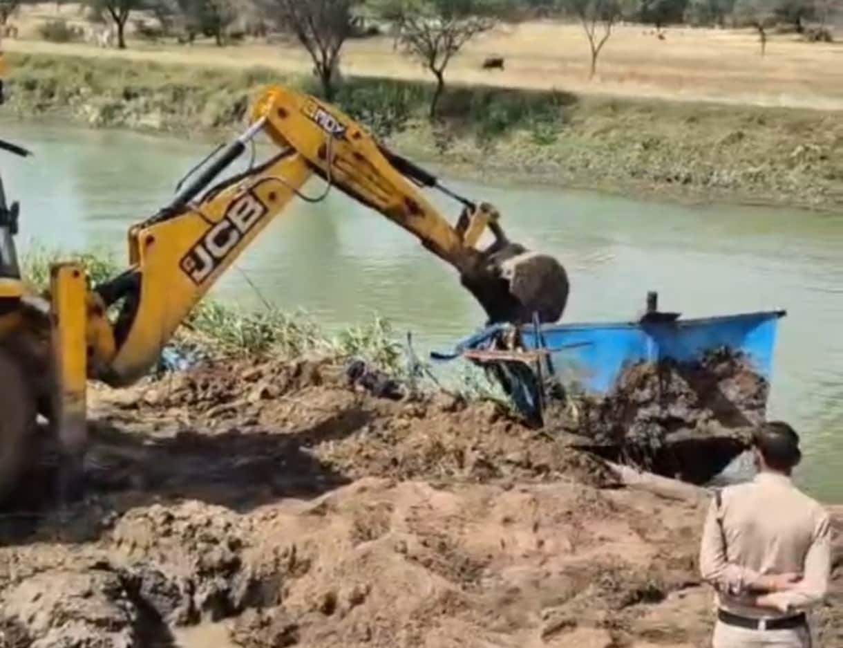पनडुब्बी को तोड़ती हुई जेसीबी।
