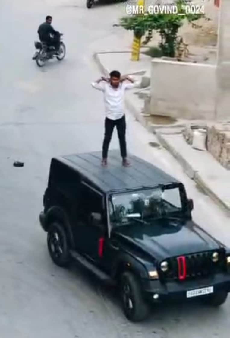 अहरौला-कप्तानगंज मार्ग पर चलती गाड़ी पर स्टंट करता युवक। संवाद