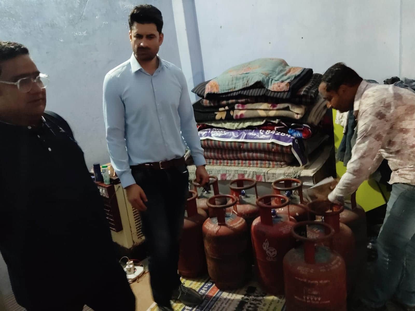 एक घर से सिलिंडर बरामद करती टीम।