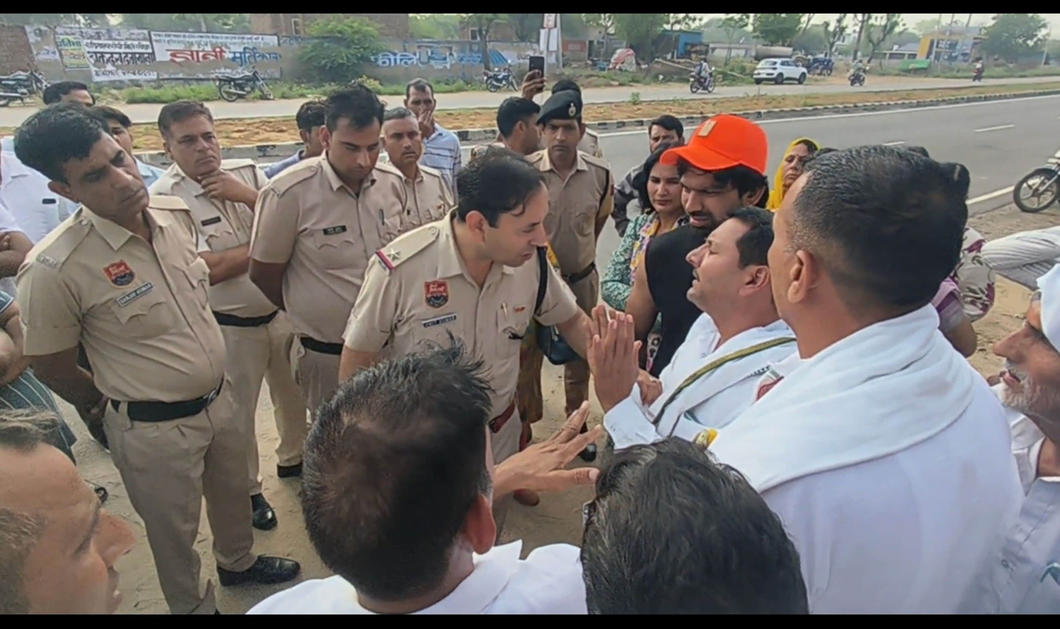 फोटो संख्या:58 आकोदा स्कूल के बाहर ग्रामीणों को समझाते आकोदा चौकी प्रभारी व पुलिसकर्मी। संवाद