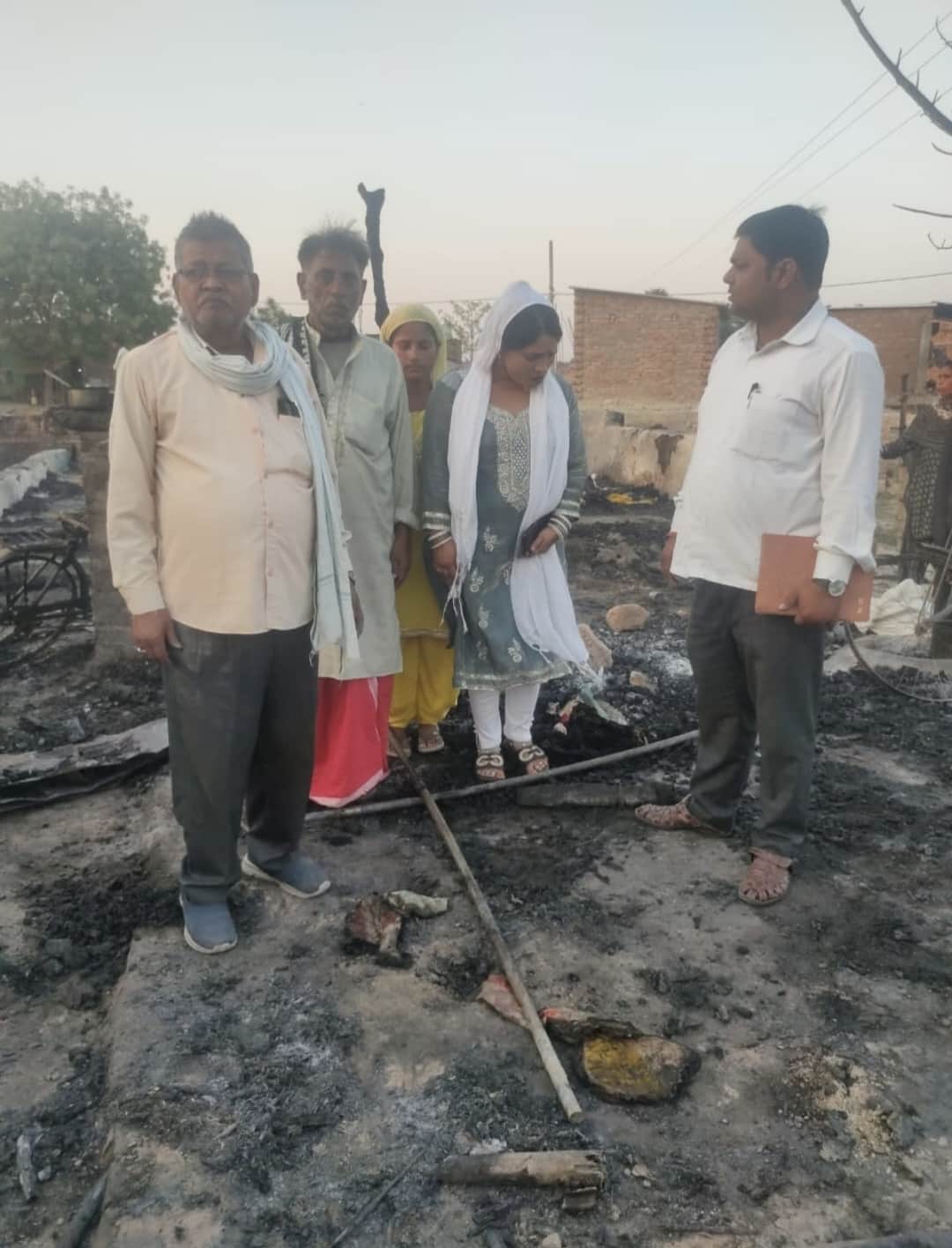 हिसामपुर में आग लगने के बाद जला सामान व मौके पर प्रधान व राजस्वकर्मी जांच करते-स्रोत ग्रामीण