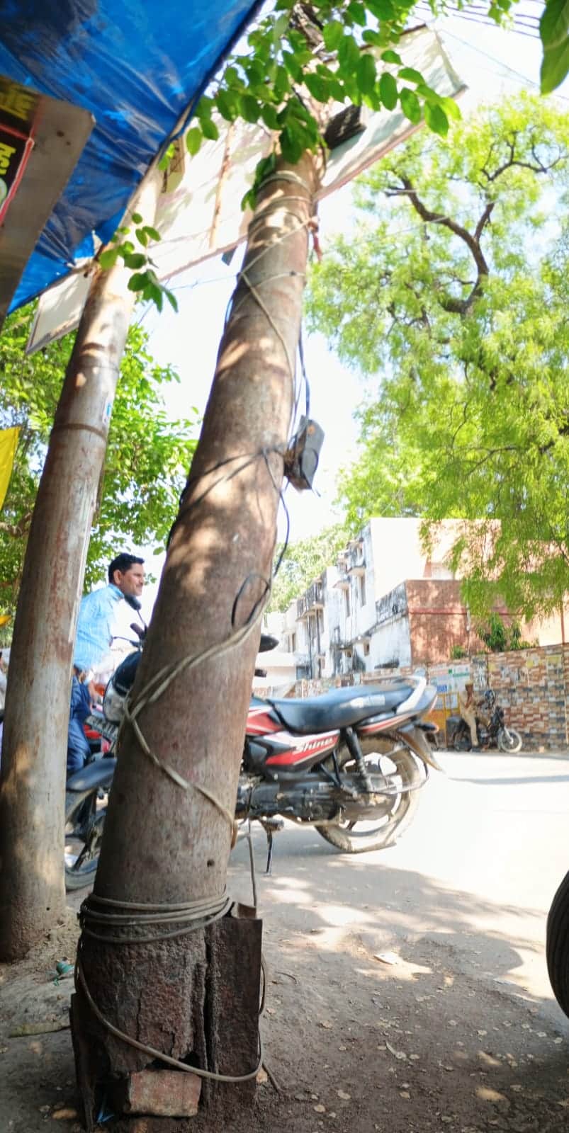 कचहरी तिराहे पर झुके बिजली के जर्जर खंभे पर लगे ऐंगल। संवाद