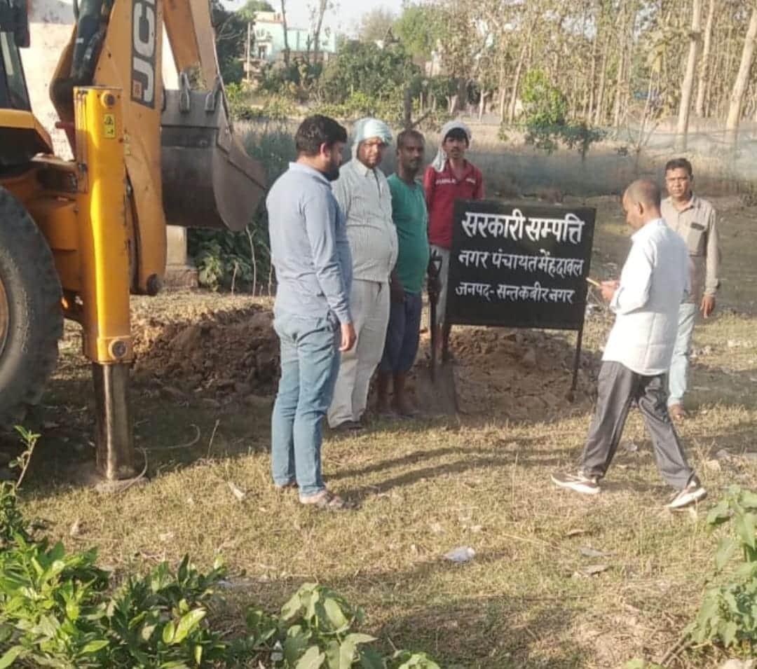 मेंहदावल में नगर पंचायत की भूमि का बोर्ड लगाते कर्मी। संवाद