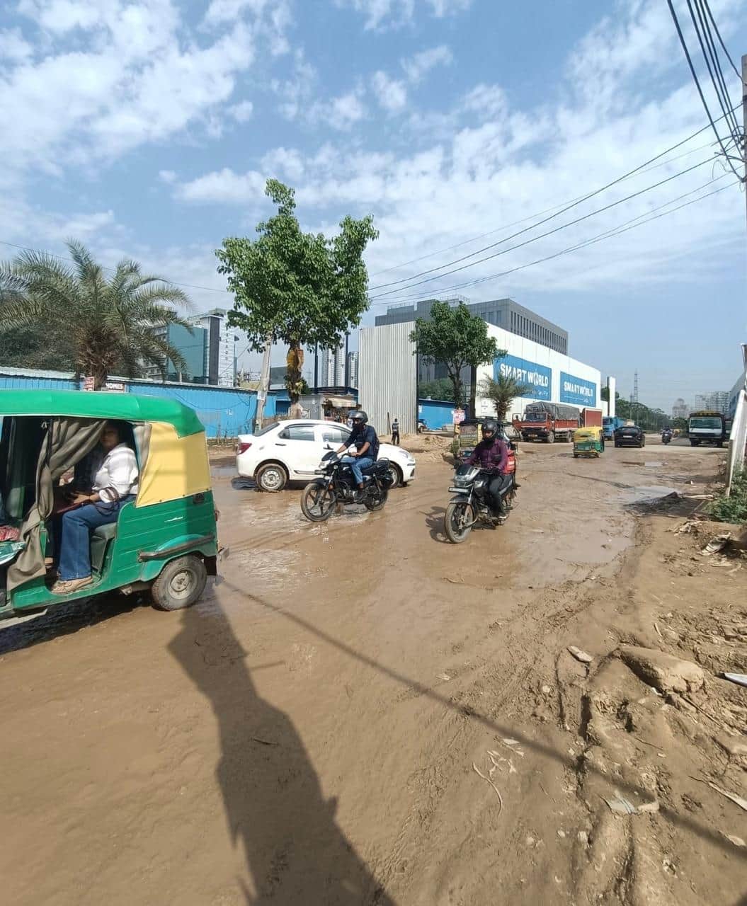 सेक्टर 69 में कीचड़ से भरी सड़क से निकलते हुए लोग। संवाद