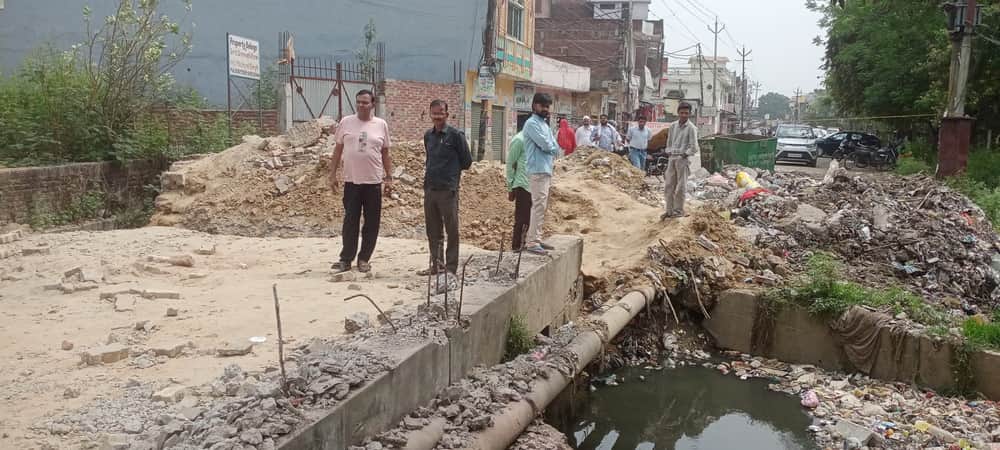 धामपुर में शीला टॉकीज के निकट इकड़ा नदी पर स्थित निर्माणाधीन पुलिया के पास लोगों की लगी भीड़ सं