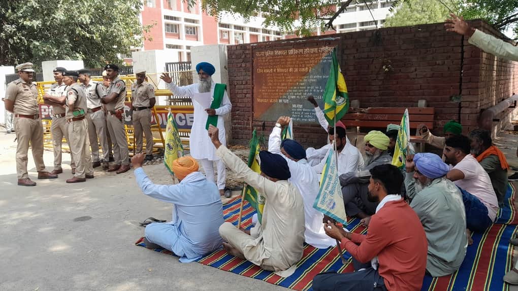 धरने पर बैठकर नारेबाजी करते किसान।