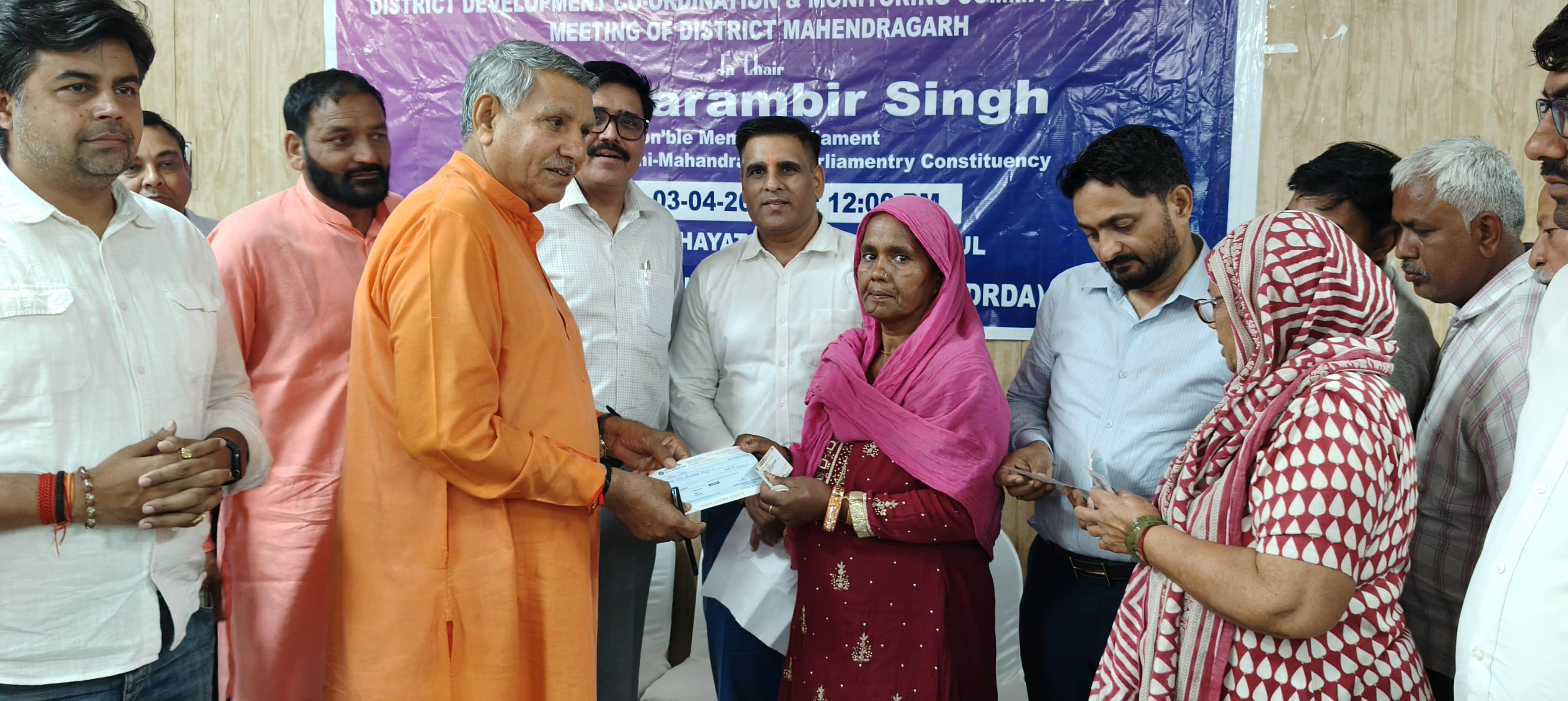 फोटो 12लाभार्थियों को चेक वितरित करते सांसद चौधरी धर्मबीर सिंह।स्रोत प्रशासन