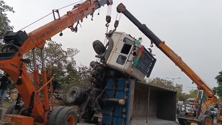 A dumper loaded with gravel overturned after hitting a divider