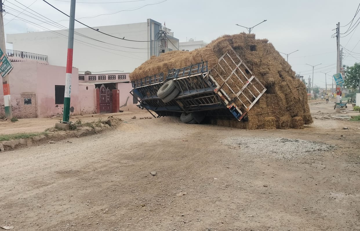 A trolley full of straw overturned on the highway