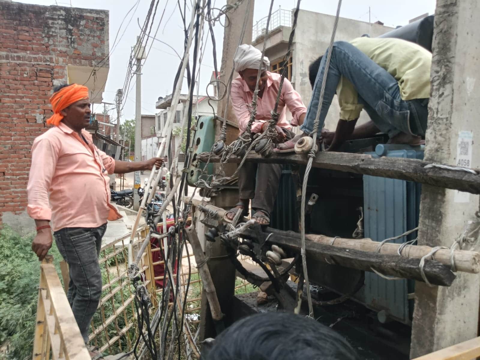 बभनान के पटेल नगर वार्ड में ट्रांसफार्मर को ठीक करता कर्मचारी-संवाद