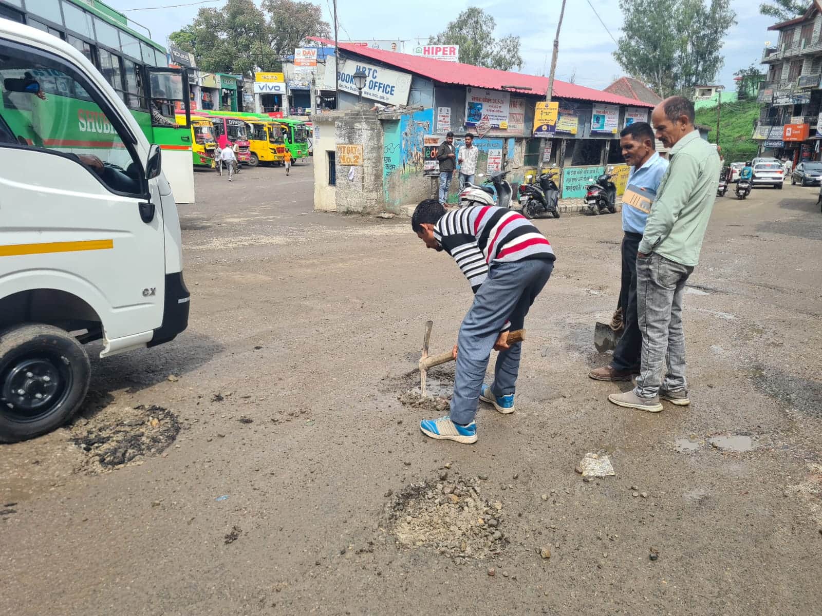 बस स्टैंड के साथ लगते राष्ट्रीय राजमार्ग पर पड़े गड्ढों की मरम्मत करते कर्मचारी। जागरूक पाठक