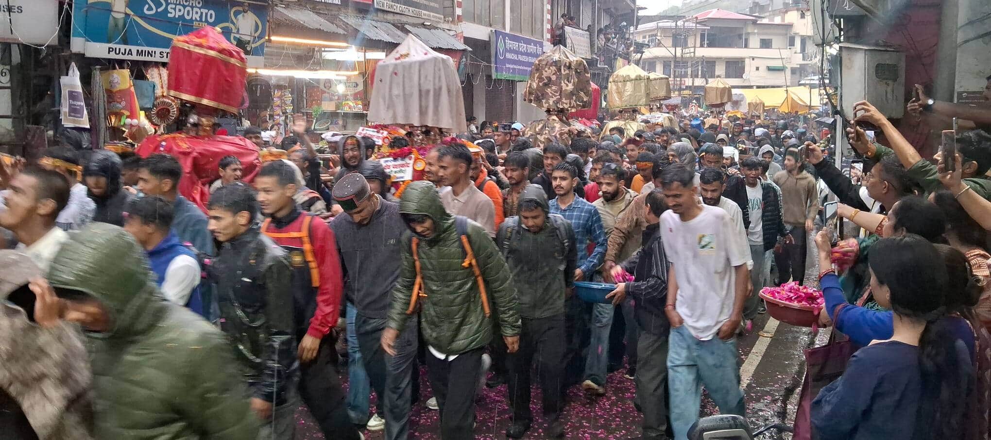 जोगिंद्रनगर देवता मेले के समापन समारोह के दौरान भारी बारिश के बीच  जलेब की अगुवाई करते देवी-देव