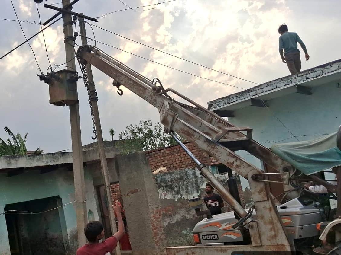 बिजली का खंभा ठीक करते कर्मचारी। संवाद