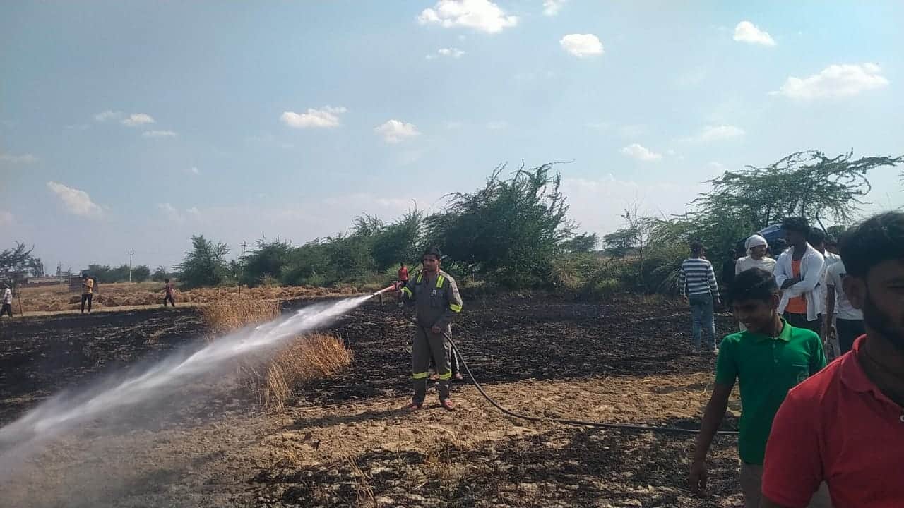 कस्बा जलेसर में खेत में लगी आग को भुझाते अग्निशमन कर्मी। संवाद