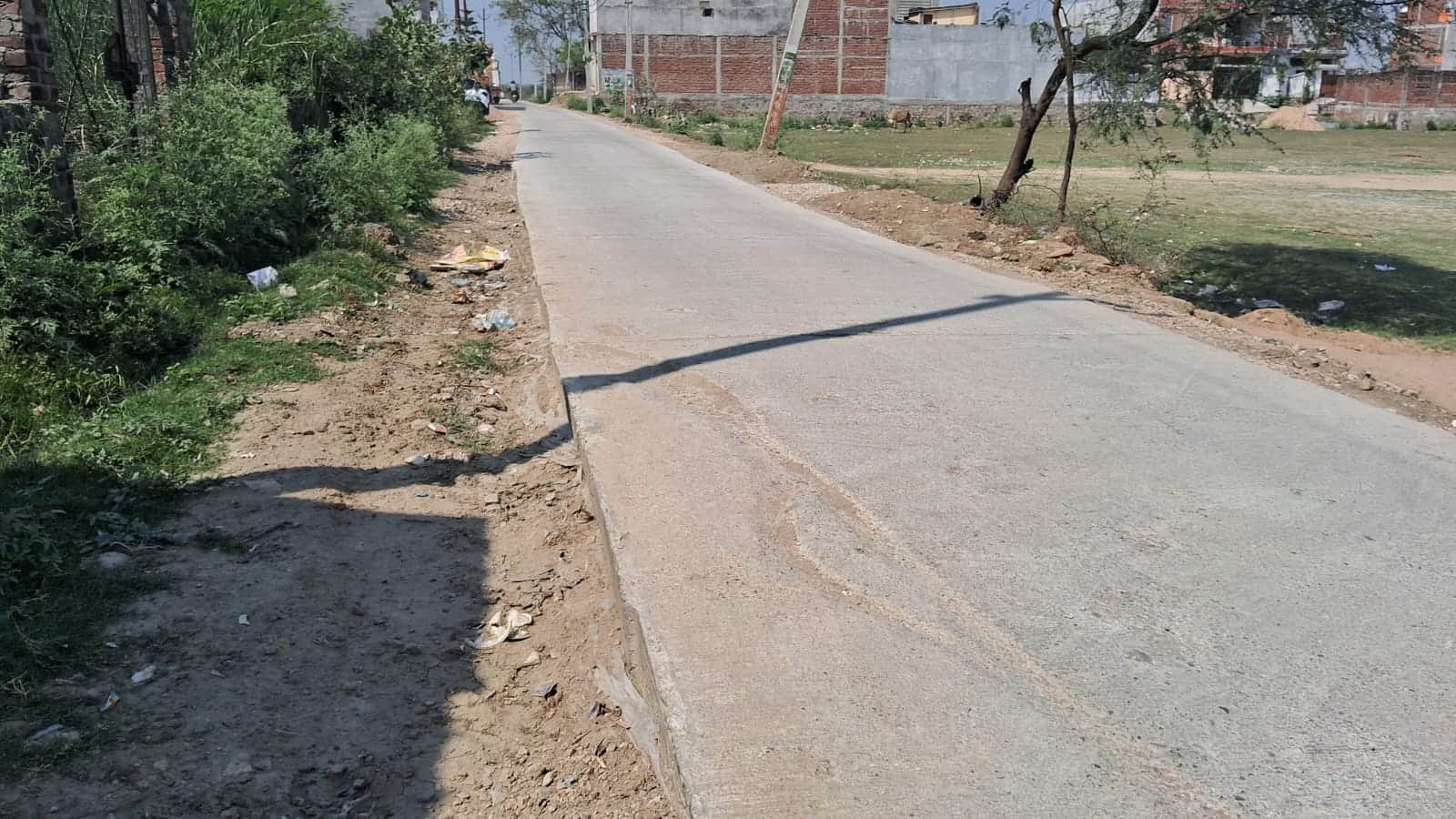 न्यू कॉलोनी में बनी आरसीसी सड़क से एक फीट नीचे पटरी। संवाद