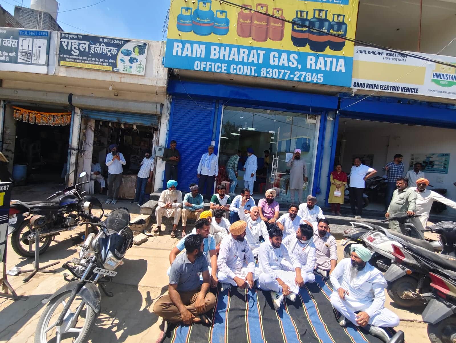 शहर की एक गैस एजेंसी के बाहर धरने पर बैठे किसान। 