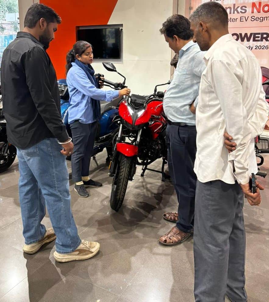 शोरूम पर बाइक देखते ग्राहक। संवाद