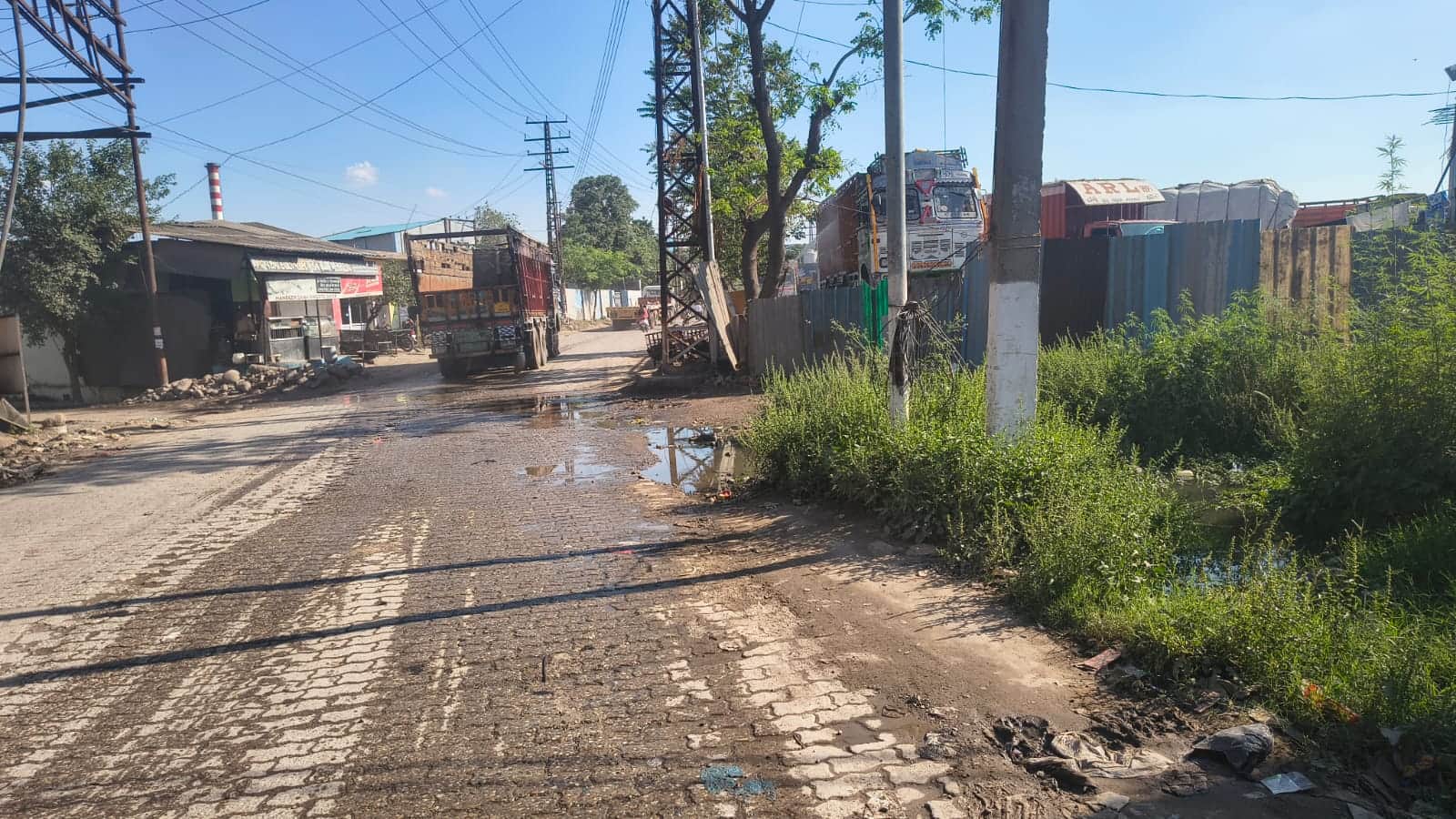 त्रिलोकपुर संपर्क सड़क पर जोहड़ों क्षेत्र में सड़क पर बहता पानी। संवाद