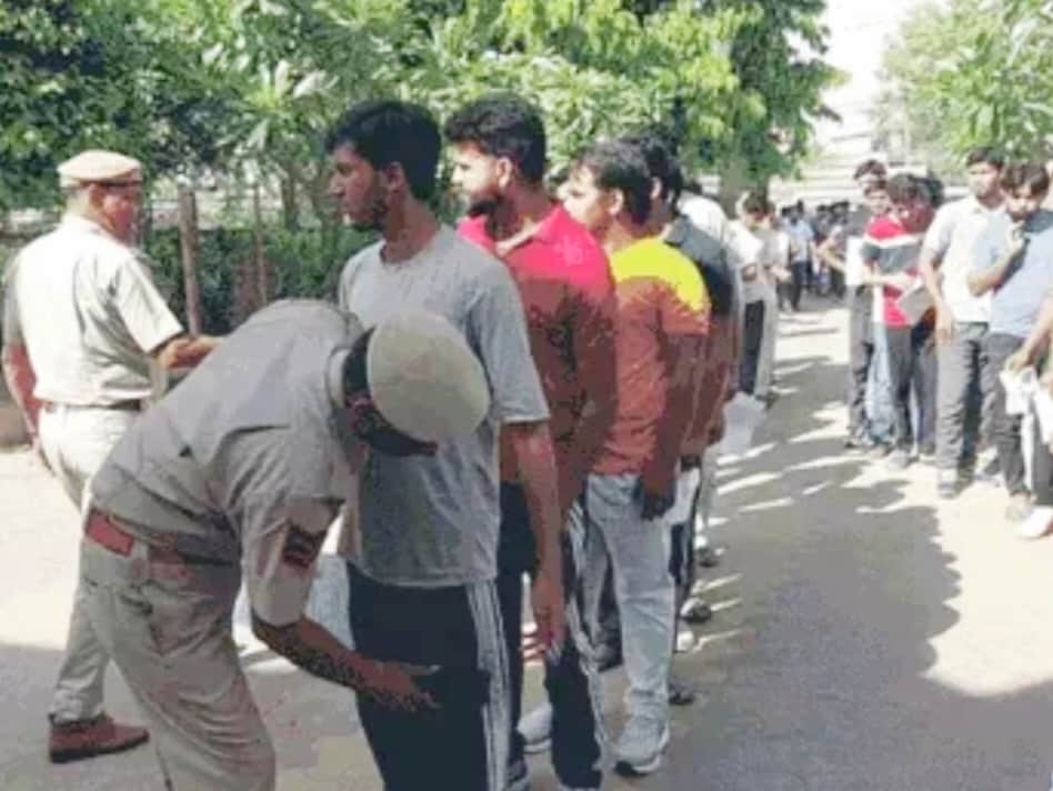 परीक्षार्थियों को प्रवेश देने से पहले जांच करते पुलिसकर्मी