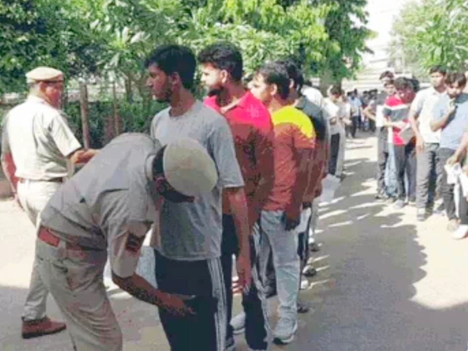 परीक्षार्थियों को प्रवेश देने से पहले जांच करते पुलिसकर्मी