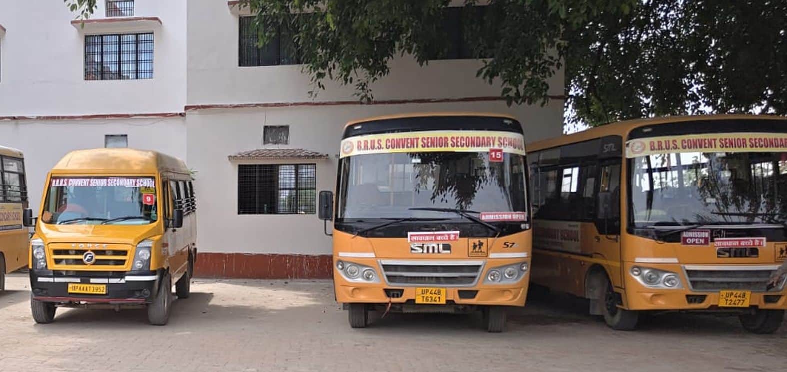 विद्यालय में खड़ी स्कूली बसें।