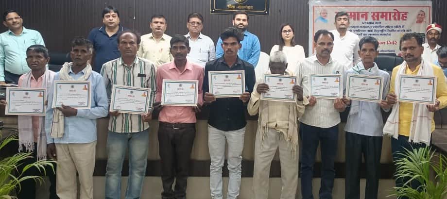 गोला के तहसील सभागार में मुआवजा प्रमाण पत्र के साथ कृषक। संवाद