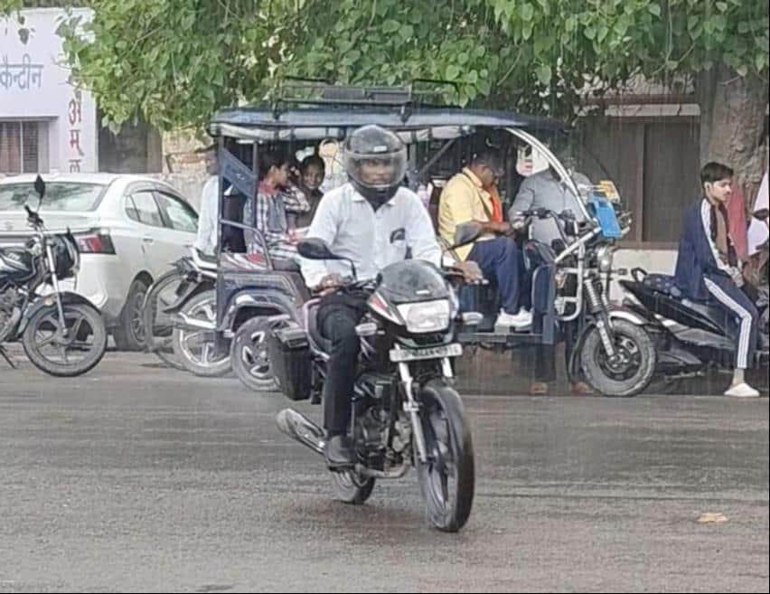 मंगलवार दोपहर बारिश होने पर शहर में भीगते हुए जाते लोग। संवाद