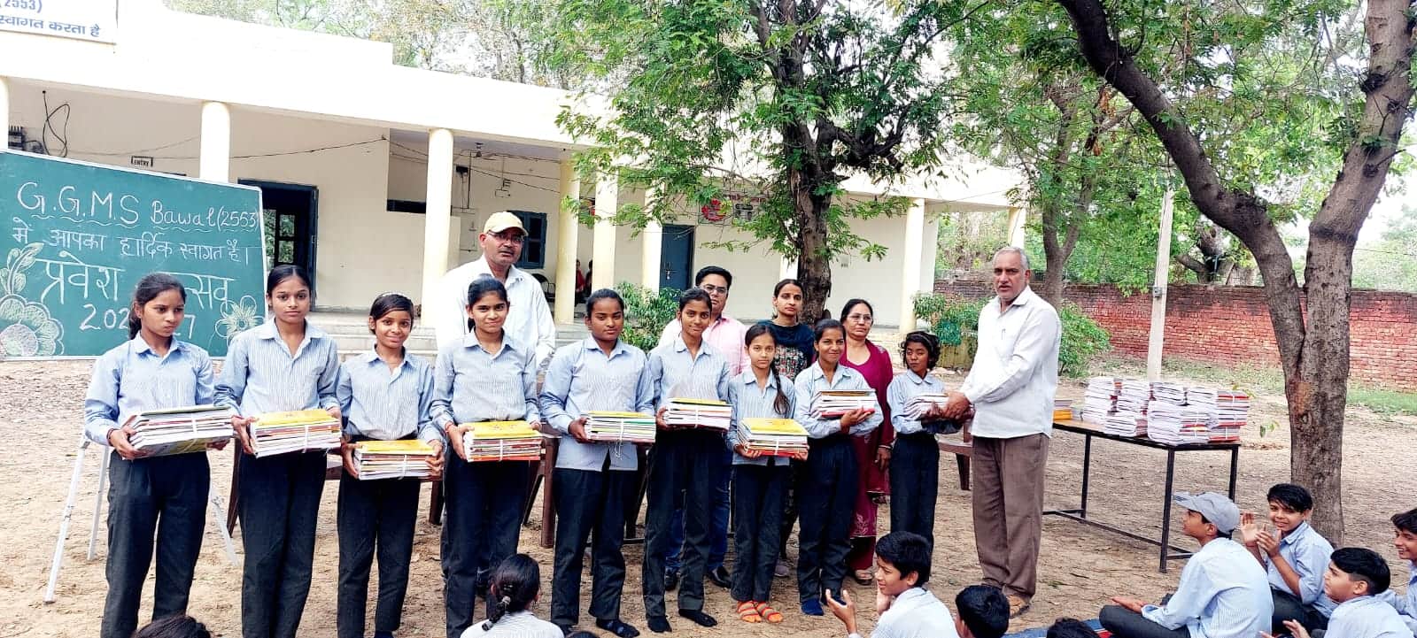 आठवीं कक्षा की पुस्तक वितरित करते वरिष्ठ प्राध्यापक डॉ. बीर सिंह। स्रोत : स्कूल