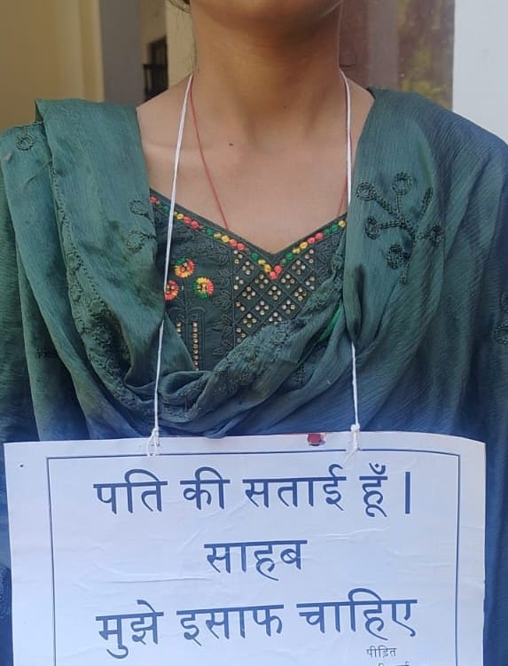Woman Reaches DM and SP Wearing a Placard Around Her Neck, Alleges: "My Husband Is Harassing Me"