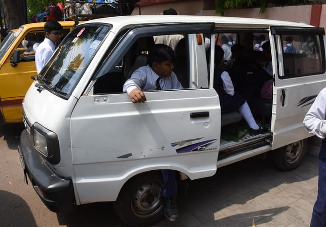 School children ride in a white van, even the driver's name is missing
