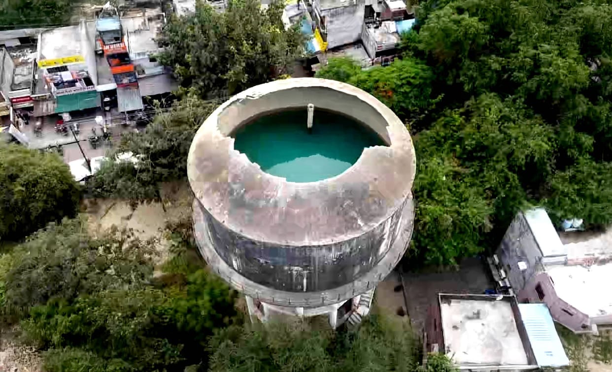 In Rajajipuram, the Jalkal department is supplying water from a tank with a broken roof.