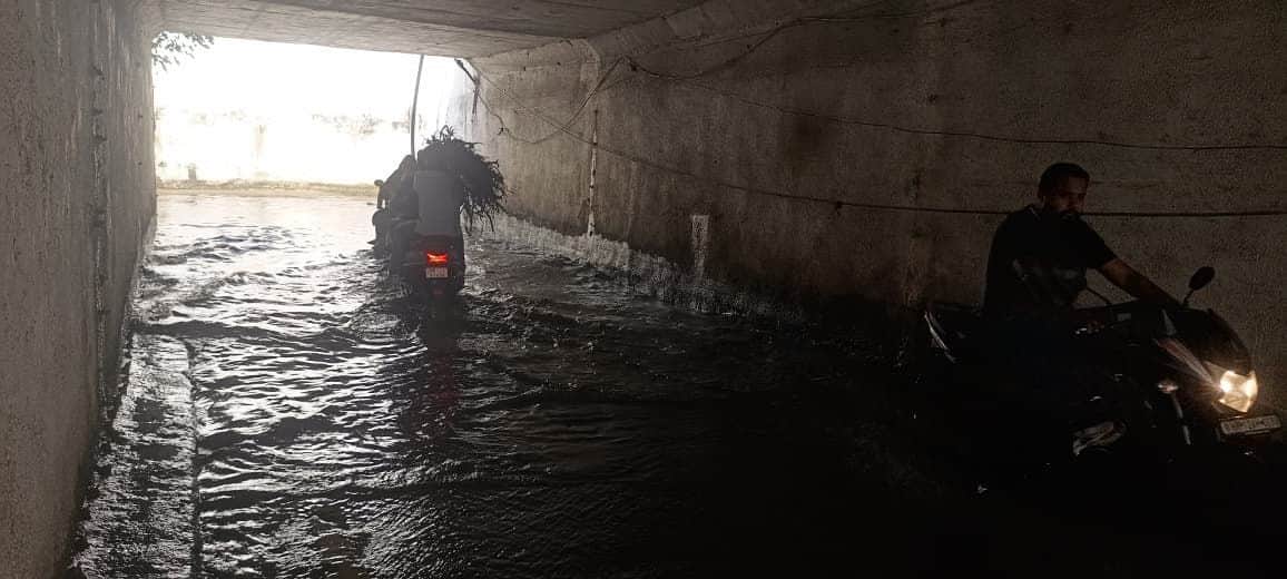 32-डबल फाटक अंडरपास में भरे पानी से गुजरते वाहन चालक।