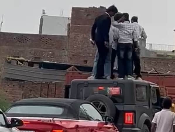 पिलखुवा में एक कार पर खड़े होकर स्टंट करते हुए युवक।स्रोत वीडियो ग्रैब